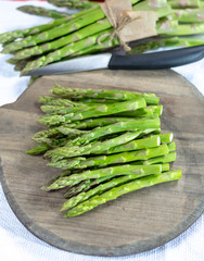 Fresh raw green asparagus vegetable on wooden plank, close up