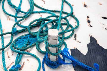 Blue tackle on rustic white boat abstract photo. Rustic blue rope on white wood. White yacht exterior detail.