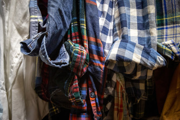 Fototapeta na wymiar Assorted Men's Shirts Hanging in a Closet