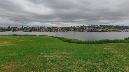 Lawn by Lake Union and houses on hills in the distance, in Gas Works Park, Seattle, USA