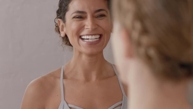 yoga class beautiful women friends chatting having conversation laughing enjoying socializing after workout in fitness studio
