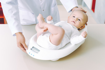 doctor weighting cute baby at home