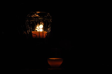 Lamp, candle shining in the darkness. Challis flame. Artistic composition. Lighting.