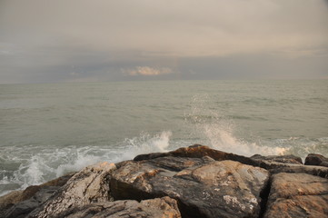 Adriatic Sea, Italy. Waves crashing against the shore against a stormy sky.