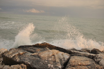 Adriatic Sea, Italy. Waves crashing against the shore against a stormy sky.