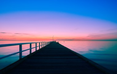 Fototapeta na wymiar Blue light after sunset over a long pier