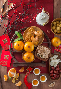 Flat lay Chinese new year food and drink still life. Translation of text in image: Prosperity.