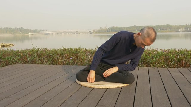 chinese man sitting and rolling his body