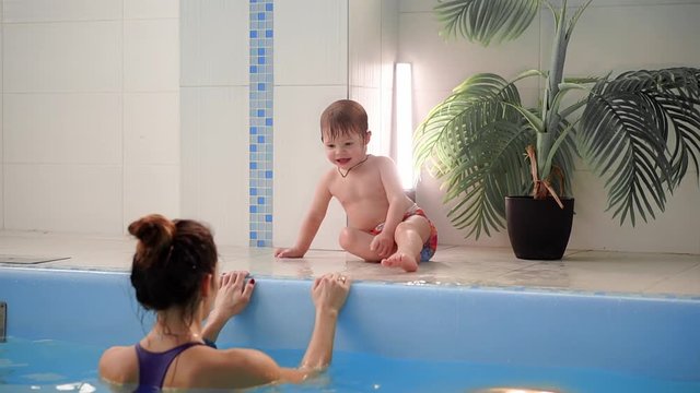 Mom explains to the child the rules of swimming in the pool