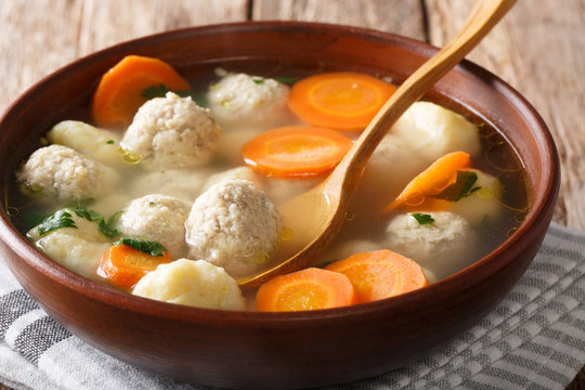 Closeup homemade chicken soup with meat balls, dumplings and vegetables in a bowl. horizontal