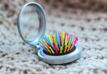 Hairbrush with mirror silver color with colored bristles