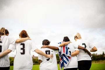 Tuinposter Female football players huddling and walking together © Rawpixel.com