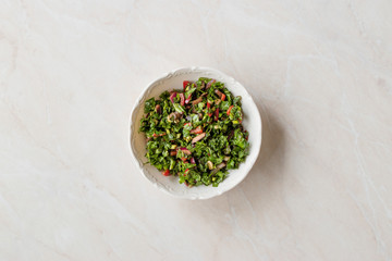Chopped Parsley Salad with Tomatoes and Onions in Ceramic Bowl on Marble Surface.