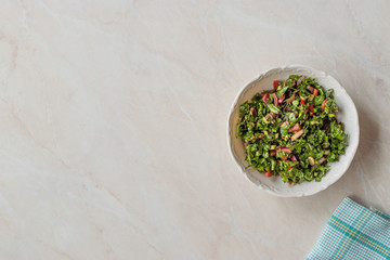 Chopped Parsley Salad with Tomatoes and Onions in Ceramic Bowl on Marble Surface.