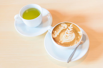 hot cappuccino coffee with green tea on table