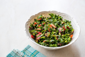 Chopped Parsley Salad with Tomatoes and Onions in Ceramic Bowl on Marble Surface.