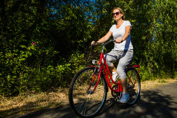 Obraz premium Healthy lifestyle - middle-aged woman riding bicycles
