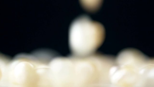 Natural golden pearl falling down in slow motion. Close up macro 4k footage.
