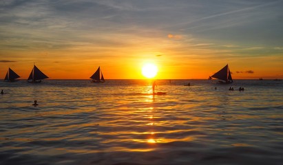 Silhouette scenery of sunset in the sea and traveler on sailboat Boracay Island, Philippines