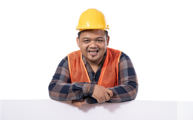 portrait of happy handyman with helmet and uniform leaning on white board