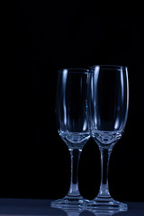 empty wine glass close-up on a black background with a place for text on the background of Christmas lights