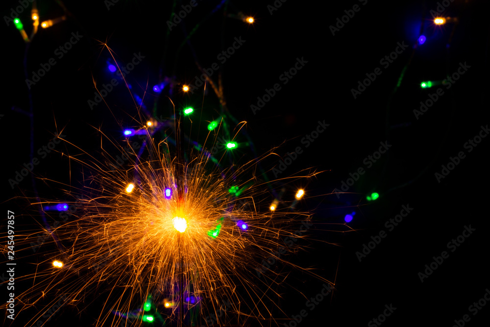 Poster festive background with sparkler and new year lights closeup