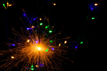 festive background with sparkler and new year lights closeup