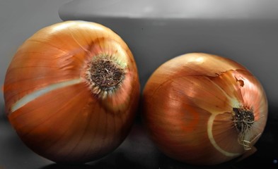 Two large yellow onions lying on the table