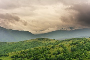 Mountain spring landscape with a small meadow in the valley.