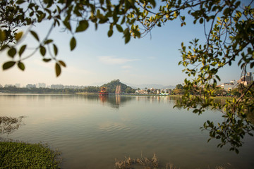 Fototapeta premium Foliage frames temples and pagodas in the distance across lake in Kaoshiung