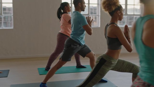 yoga class of young healthy people practicing triangle pose enjoying fitness lifestyle exercising in studio at sunrise