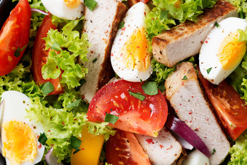 Fresh vegetable salad with chicken breast and eggs.