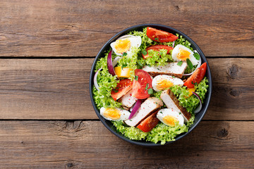 Fresh vegetable salad with chicken breast and eggs.