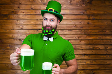 Happy young adult man male in green shirt, green leprechaun hat and tie bow with lucky clover...