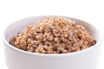 Boiled buckwheat in white plate on white isolated background