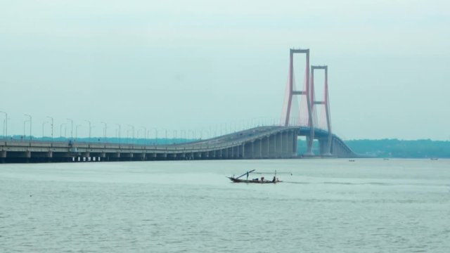Landscape of Madura Strait with boat and Suramadu Bridge background at Surabaya city, East Java, Indonesia. Shot in 4k resolution