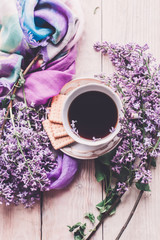 Fototapeta na wymiar Morning cup of tee, cookies, and lilac flower on wooden table from above. Beautiful breakfast. Flat lay style with copy space