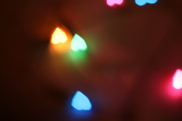 Bokeh light that has a heart shape of many sizes and has a lot of colors on a background with blur and darkness.