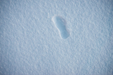 Foot print on the white snow as a background