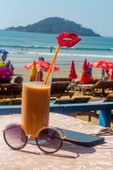 yummy and delicious smoothie on the beach during holidays with lips mask on straw