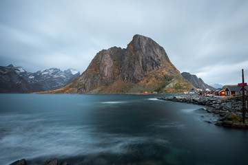 Fototapeta na wymiar Long exposure of red fishing rorbuer house village with mountain view in Lofoten island Hamnoy Norway
