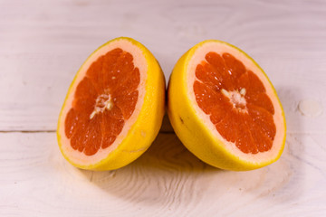 Ripe juicy grapefruit on a white wooden table