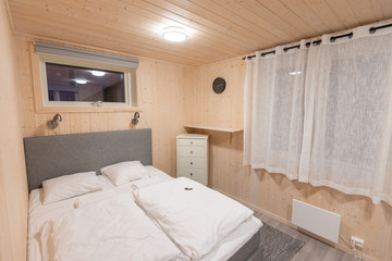 Fototapeta na wymiar Bed with white blanket and pillow in the little modern hut