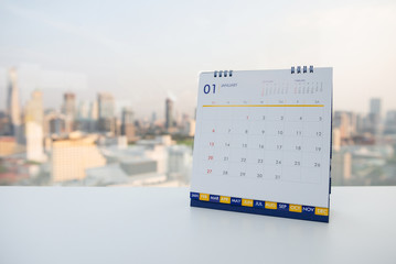 Calendar of January on the white table with city view background