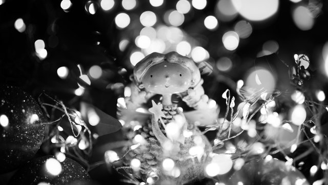 Christmas themed pupet with christmas lights and christmas ball bokeh still life black and white