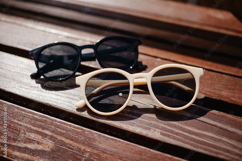 Wall mural stylish sunglasses and on a wooden background