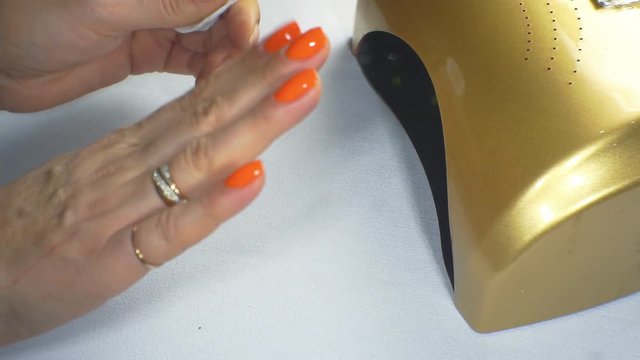Woman dries her nails with shellac in UV lamp. Close-up. 1920X1080 Full Hd.