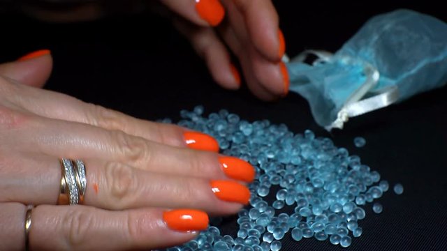 Women's hands hold a blue topaz or a precious stone and check the quality. 1920X1080 Full Hd.
