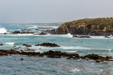 Beautiful seascape. Waves hitting massive cliffs. Rock in the water. Cloudy day. Nature scenery.