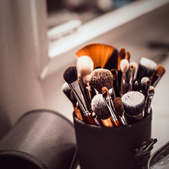 Makeup artist tools-makeup brushes on the table with a mirror.